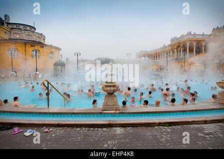 Touristen und Einheimische genießen die Széchenyi-Thermen an einem kalten Wintertag, Budapest, Ungarn Stockfoto