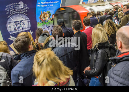 London, UK. 16. März 2015. Passagiere erwarten verpackt Northern Line-Züge an der Station Stockwell. Sie sind durch Ankündigungen bombardiert, dass alle Linien einen guten Service haben und durch eine hilfreichen Zeichen stehen, Aufmachungen von TFL, sagen sie nicht, um eine Tür zu drängen. Leider sind sie vom Gewicht der Zahlen gezwungen, gefährlich nah an der Bahnsteigkante stehen.  Stockwell Station auf der Northern Line, London Unerground, 16. März 2015. Bildnachweis: Guy Bell/Alamy Live-Nachrichten Stockfoto