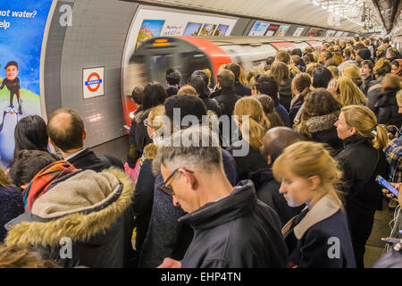 London, UK. 16. März 2015. Passagiere erwarten verpackt Northern Line-Züge an der Station Stockwell. Sie sind durch Ankündigungen bombardiert, dass alle Linien einen guten Service haben und durch eine hilfreichen Zeichen stehen, Aufmachungen von TFL, sagen sie nicht, um eine Tür zu drängen. Leider sind sie vom Gewicht der Zahlen gezwungen, gefährlich nah an der Bahnsteigkante stehen.  Stockwell Station auf der Northern Line, London Unerground, 16. März 2015. Bildnachweis: Guy Bell/Alamy Live-Nachrichten Stockfoto