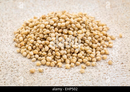 ein Haufen von Gluten-freie weiße Sorghum-Korn gegen rustikale Scheune Holz Stockfoto