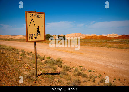 Ein Verkehrszeichen Warnung vor tiefen Minenschächte in Opal Bergbau Land, Coober Pedy, Australien Stockfoto