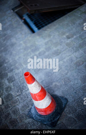 Arbeiten in einem Abwasserkanal auf einem gepflasterten Platz Stockfoto