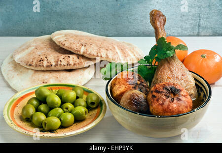 Marokkanische Ente Bein Tajine mit Mandarinen, Zwiebeln und frischer Koriander, serviert mit Pita Brot und grünen Oliven. Stockfoto