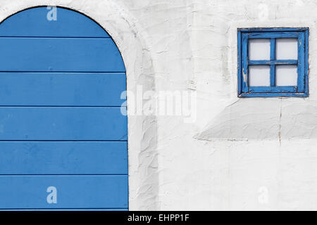 Alte hölzerne blaue Tür und Fenster mit weißen Wand Stockfoto