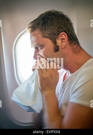 Reiseübelkeit. Mann fühlt sich sehr schlecht auf das Flugzeug. Stockfoto