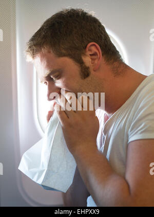 Reiseübelkeit. Mann fühlt sich sehr schlecht auf das Flugzeug. Stockfoto