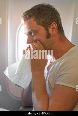 Reiseübelkeit. Mann fühlt sich sehr schlecht auf das Flugzeug. Stockfoto