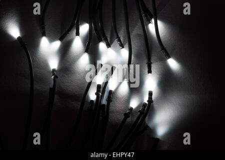 Mini leuchtet die spitzen Enden der optische Glasfaser-Kabel Ausleuchtung eines kleinen Scheinwerfer mit leuchtend helle und dunkle Schatten Stockfoto