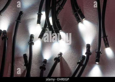 Mini leuchtet die spitzen Enden der optische Glasfaser-Kabel Ausleuchtung eines kleinen Scheinwerfer mit leuchtend helle und dunkle Schatten Stockfoto