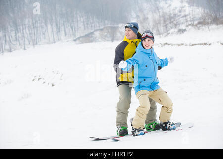 Junger Mann, Freundin, snowboard Unterricht Stockfoto