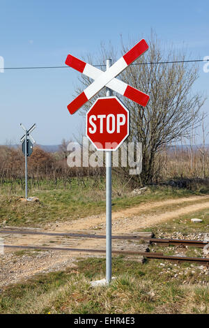 unbewachten Bahnübergang mit St. Andrews Kreuz im zeitigen Frühjahr Stockfoto