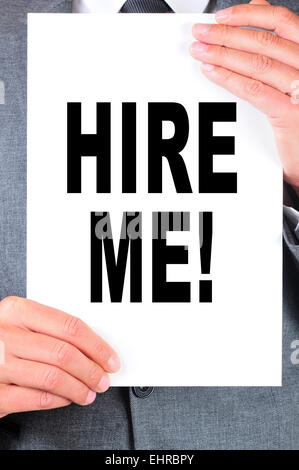 ein Mann in einem Anzug hält ein Schild mit dem Text Verleih mich darauf geschrieben Stockfoto