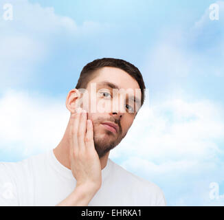 schöne ruhige Mann sein Gesicht berühren Stockfoto