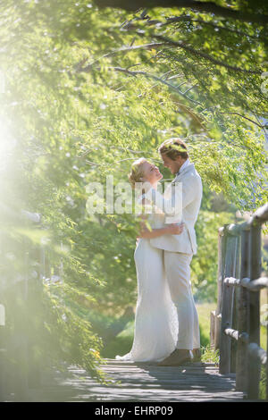 Junges Paar auf Holzbrücke umarmen Stockfoto