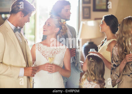 Junges Paar mit Gästen und Sektgläser bei Hochzeitsfeier Stockfoto