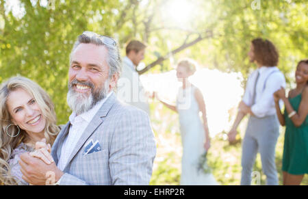 Matrone der Ehre mit Trauzeuge tanzen während der Hochzeitsfeier im heimischen Garten Stockfoto