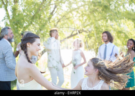 Brautjungfer und Mädchen tanzen während der Hochzeitsfeier im heimischen Garten Stockfoto