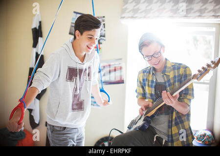 Zwei Jungs im Teenageralter, die Spaß und spielt e-Gitarre im Raum Stockfoto