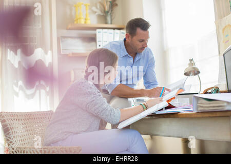 Vater Tochter im Teenageralter bei ihren Hausaufgaben helfen Stockfoto