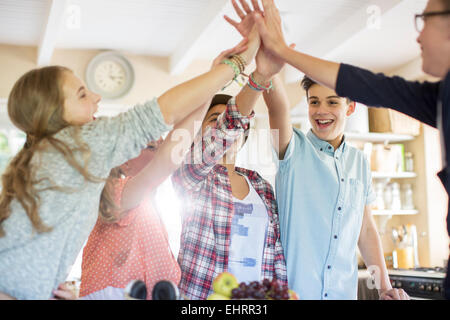 Gruppe von Jugendlichen, die hohe fünf im Wohnzimmer zu tun Stockfoto