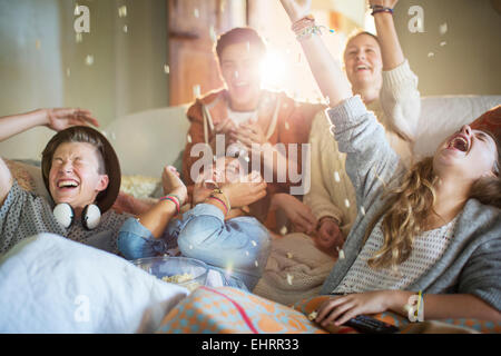 Gruppe von Jugendlichen werfen Popcorn auf sich auf sofa Stockfoto