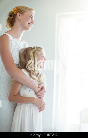 Braut umarmen Brautjungfer und Blick aus Fenster