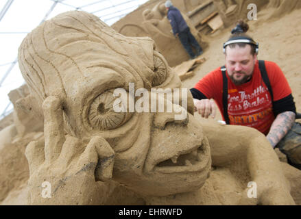 Binz, Deutschland. 17. März 2015. Der Bildhauer Pasi Ahokas aus Finnland arbeitet auf eine Sandskulptur "Gollum" aus dem Film "Lord of the Rings" an das Sandskulpturenfestival in Binz, Deutschland, 17. März 2015. Künstler aus verschiedenen europäischen Ländern schaffen 45 riesige Figuren für die 6. Sandskulpturen-Show. In diesem Jahr sind Prominente aus TV und Kino, sowie berühmte TV- und Film-Szenen, im Mittelpunkt der Ausstellung. Die Sandskulpturen-Ausstellung öffnet am 21. März 2015. Bildnachweis: Dpa picture Alliance/Alamy Live News Stockfoto