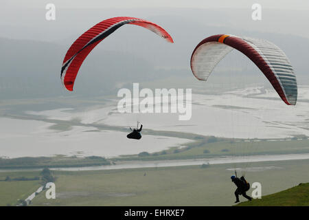 Ein Mitglied des südlichen Hang Gliding Club startet selbst in die Luft über Überschwemmungsgebiete des Cuckmere Valley im Süden D Stockfoto