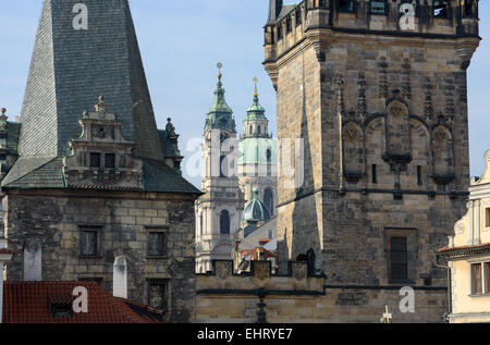 Nahaufnahme der Kuppel und Glockenturm der Kathedrale Sankt Nikolaus zwischen Türmen der Karlsbrücke auf der Seite der Kleinseite Stockfoto