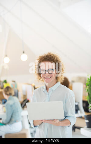 Porträt der Frau mit Laptop im Büro Stockfoto