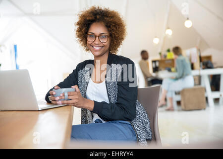 Büroangestellte mit Kaffee mit laptop Stockfoto