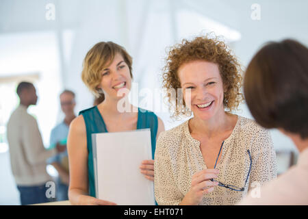 Büroangestellte, plaudern und lachen während der Sitzung Stockfoto