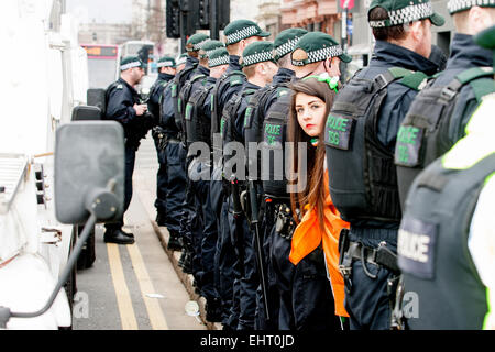 Belfast UK. 17. März 2015 Teenage Mädchen trägt eine Trikolore Pop ihren Kopf durch eine Reihe von TSG Polizisten an einer Loyalisten Flagge außerhalb der Belfast City Hall am St. Patricks Day Credit Protest: Bonzo/Alamy Live News Stockfoto