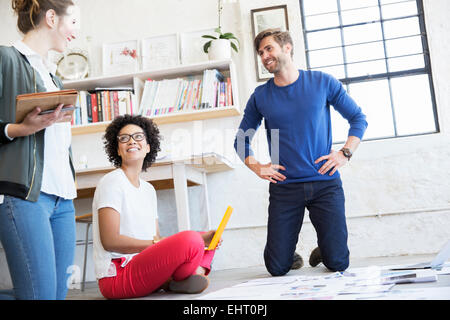 Porträt von drei jungen Leuten am Boden sitzen und arbeiten zusammen Stockfoto