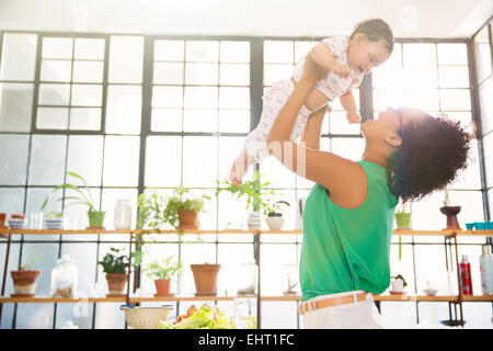 Mutter ihre Tochter über Kopf heben Stockfoto