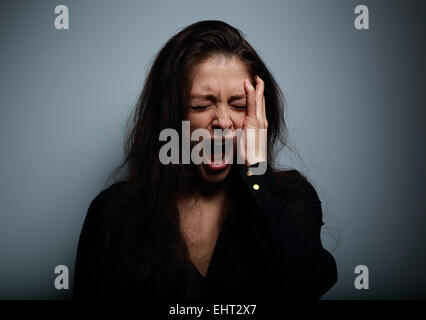 Closeup Portrait Frau wütend, traurig und verzweifelt schreien auf dunklem Hintergrund Stockfoto