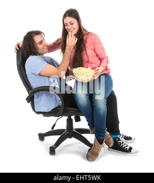 Mann und Frau sitzen zusammen im Sessel essen Popcorn, isoliert auf weiß Stockfoto