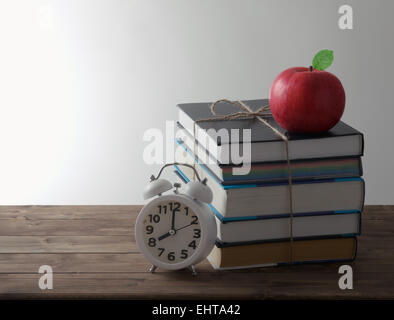 Satz von Büchern mit Alarm und rote Apfel-Bildungskonzept Stockfoto