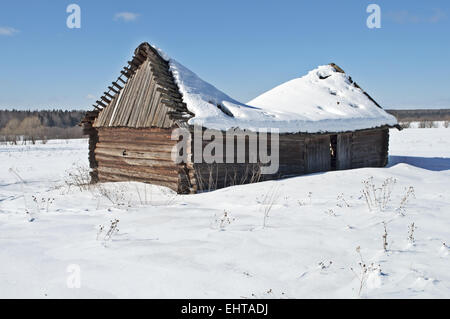 Alte hölzerne Scheune unter Schnee Stockfoto