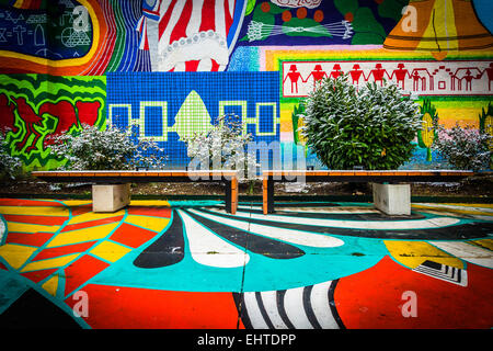 Bänke und bunte Wandgemälde im Norden Charles, Baltimore, Maryland. Stockfoto