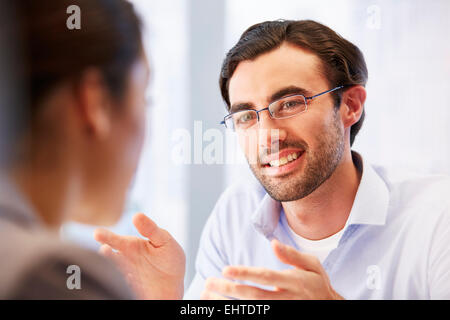 Lächelnder Mann in Gläsern im Büro mit client Stockfoto