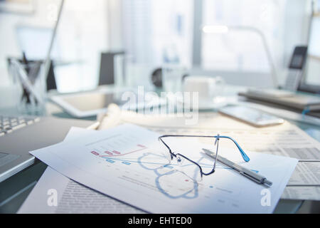 Ansicht des unordentlichen Schreibtisch mit Brille und Stift auf Papier Stockfoto