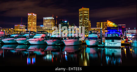 Boote und die Skyline bei Nacht, im Inneren Hafen von Baltimore, Maryland. Stockfoto