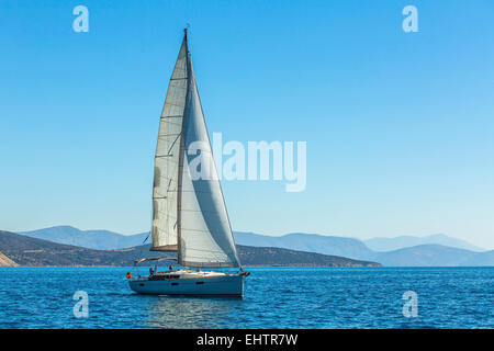 Yacht bewegt sich entlang der Küste. Segelyacht im blauen Meer. Stockfoto