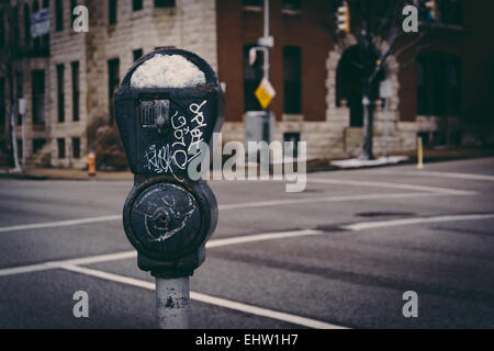 Schneebedeckte Parkuhr in Charles North, Baltimore, Maryland. Stockfoto