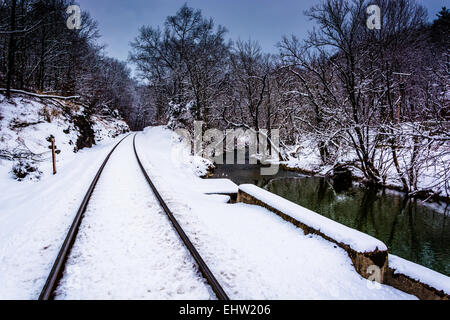 Verschneite Bahngleis und Creek im ländlichen Carroll County, Maryland. Stockfoto