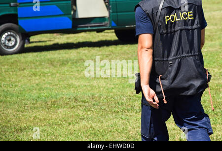 Polizist geht auf das Polizeifahrzeug Stockfoto