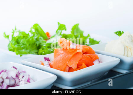 Geräucherter Lachs Lox-Plattenteller mit roten Zwiebeln und Frischkäse. Stockfoto