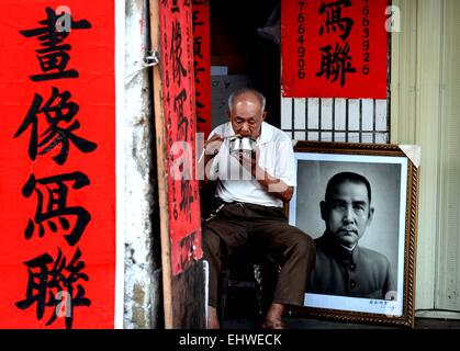 (150318)--Peking, 18. März 2015 (Xinhua)--ein Alter Mann hat Mittagessen auf einem Corrdior ein Qilou Gebäude in Haikou, der Hauptstadt der Provinz Süd-China Hainan, 31. März 2014. Qilou Gebäude oder Arcade-Häuser, waren die ersten in Europa populär und wurde dann in die Welt eingeführt. Chinas erste Qilou Gebäude entstand in Guangzhou, Hauptstadt der südchinesischen Provinz Guangdong, die auch unter den ersten Küstenstädten zu umarmen fremde Kultur und Modernisierung zu beginnen. In den 30er und 40er Jahren begann die Qilou Architektur in den südlichen Teilen Chinas wie Guangdong, Guangxi, Hainan und Fujia durchsetzen Stockfoto