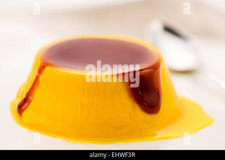 Creme, Karamell Dessert mit einer leckeren braunen Karamell Sauce auf dem Silbertablett serviert beträufelt, Nahaufnahme Stockfoto